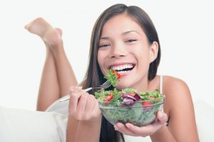 Smiling woman eating a salad